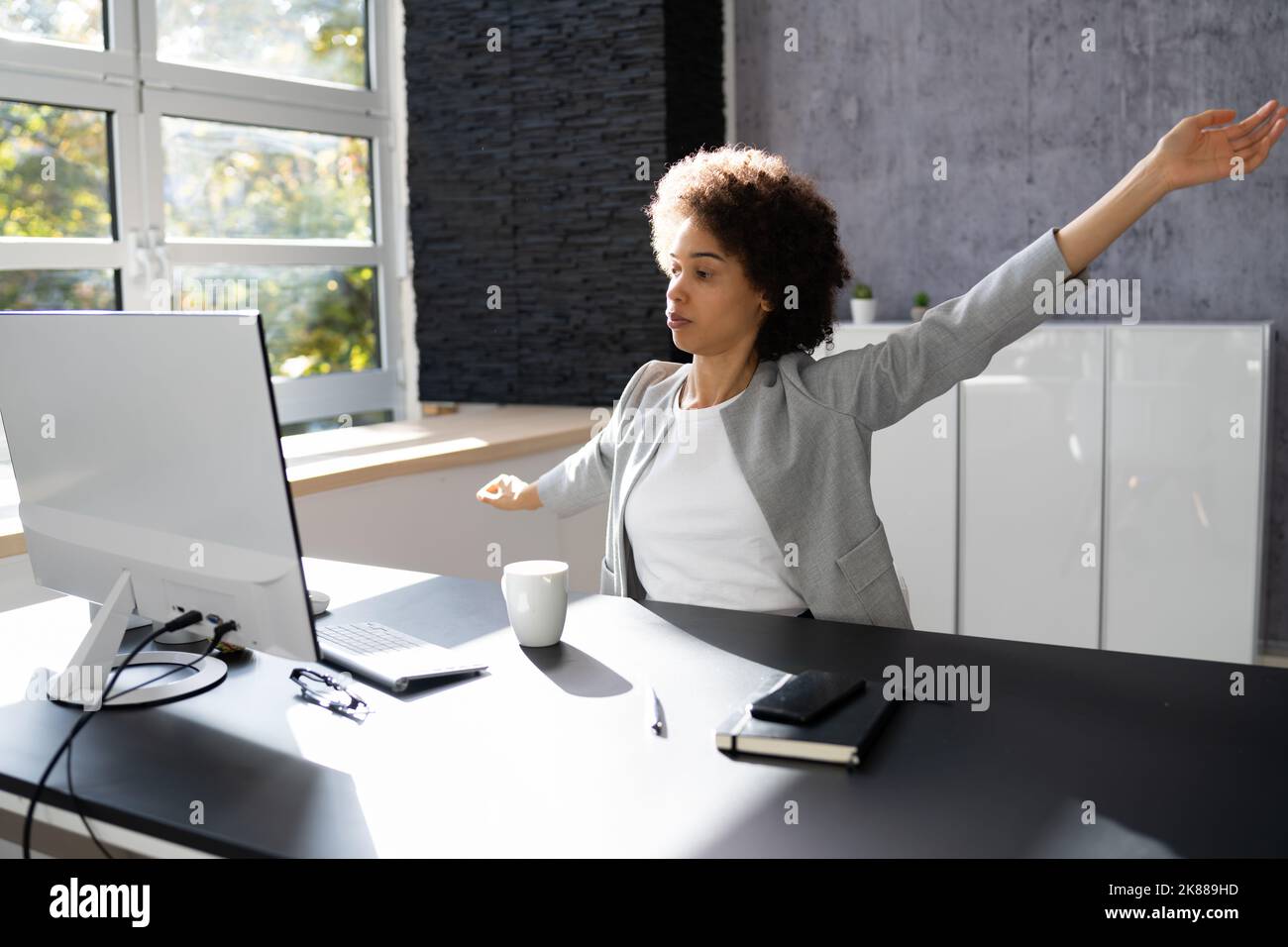 Femme faisant de l'exercice de yoga de bureau asseyez-vous et étirez-vous au bureau Banque D'Images