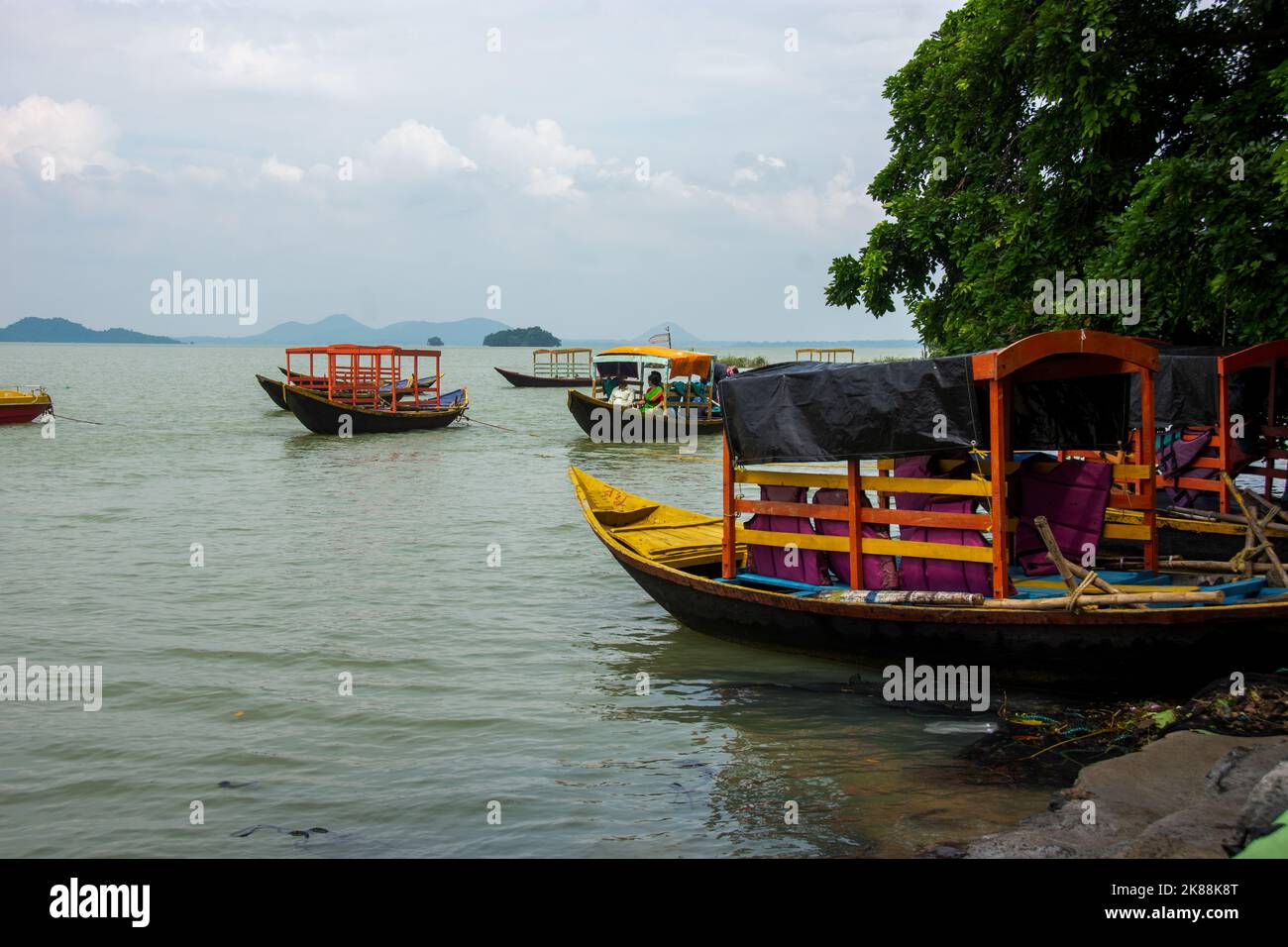 Bateau traditionnel en bois attaché à une rive de rivière par temps pluvieux Banque D'Images