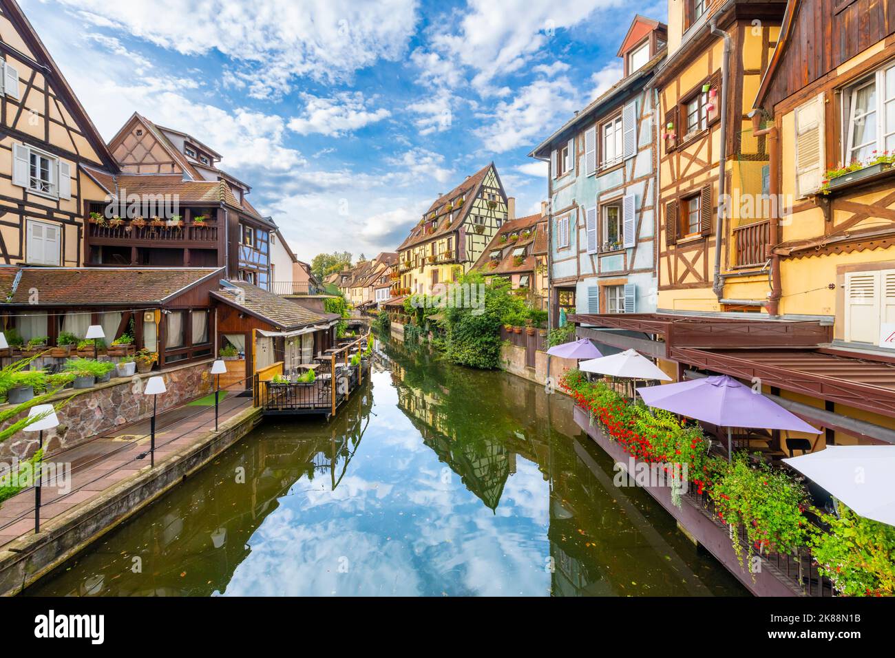 Des bâtiments à colombages colorés et des cafés en bord de mer sur la rivière Lauch dans le quartier médiéval historique de la petite Venise de Colmar, en France. Banque D'Images