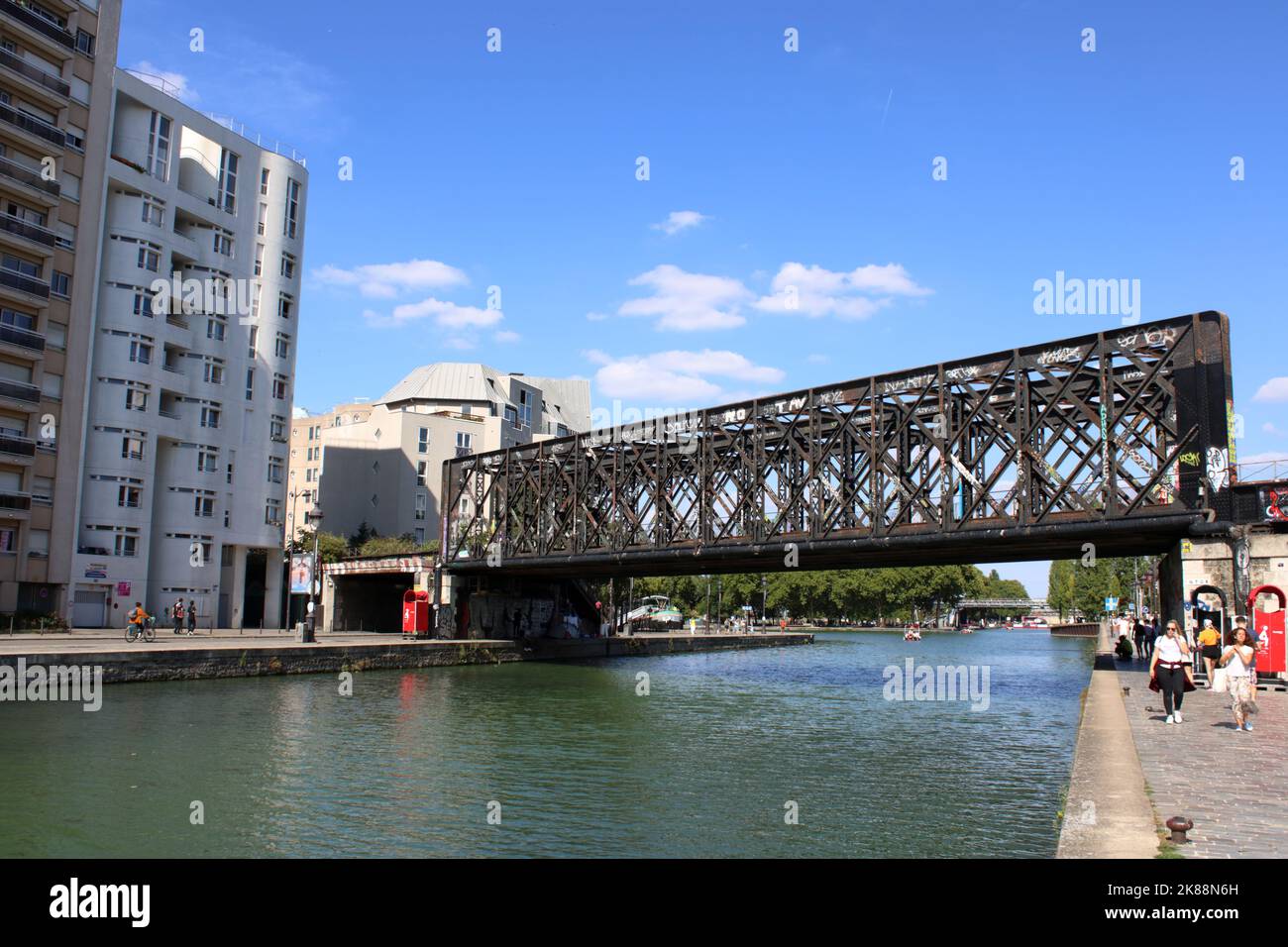 Vue sur un pont ferroviaire et des bâtiments résidentiels sur le bassin de la Villette le long du quai de la Marne dans le 19th arrondissement de Paris France. Banque D'Images
