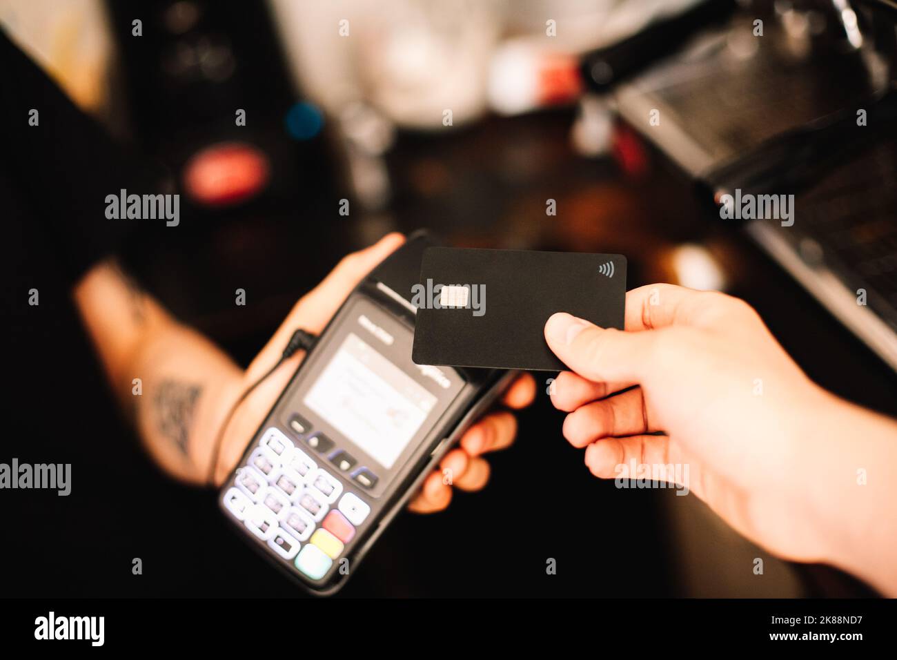 Client effectuant un paiement sans contact à l'aide d'une carte de crédit Banque D'Images