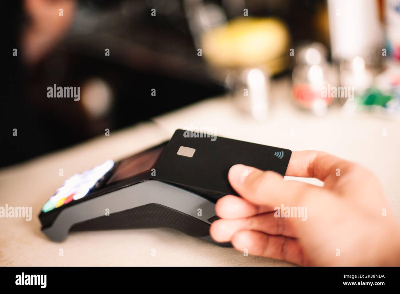 Client effectuant un paiement sans contact à l'aide d'une carte de crédit Banque D'Images