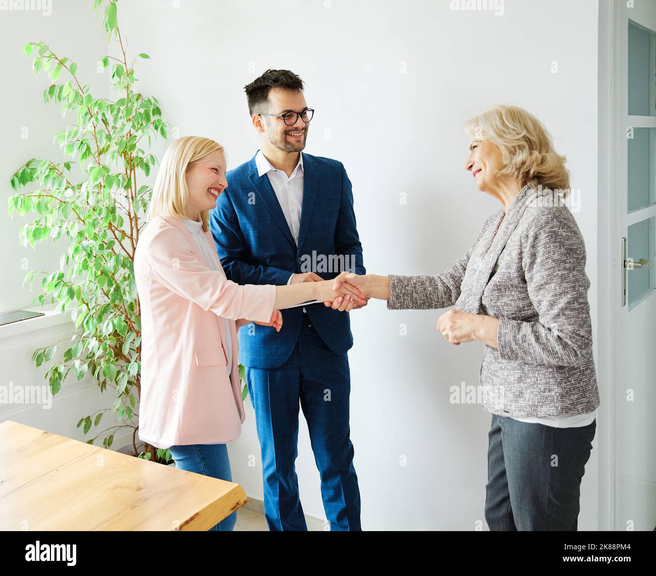 un jeune couple qui tremble les mains traite contrat d'investissement immobilier agent d'accord d'affaires poignée de main signature Banque D'Images