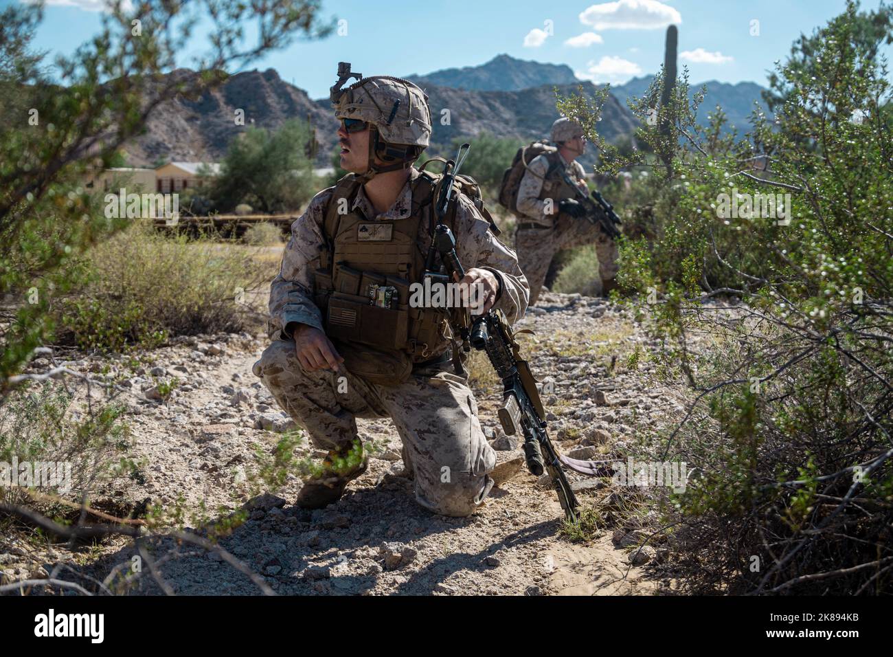 Caporal du corps des Marines des États-Unis Drew Daugherty, Foreground, un rifleman avec 2nd Bataillon, 7th Marine Regiment, 1st Marine Division, appelle à la coordination des commandements pendant les tactiques de soutien d'assaut 1 (AST-1) dans le cadre du cours d'instructeur d'armes et de tactiques (WTI) 1-23, à la zone d'entraînement de combat Village, Wellton, Arizona, le 17 octobre 2022. AST-1 est un événement de jour, force-sur-force qui offre à WTIS prospective l'occasion de planifier, de briefer et d'exécuter un assaut aérien renforcé par la compagnie tout en intégrant les six fonctions de Marine Aviation. (États-Unis Photo du corps marin par lance Cpl. Dean Gurule) Banque D'Images