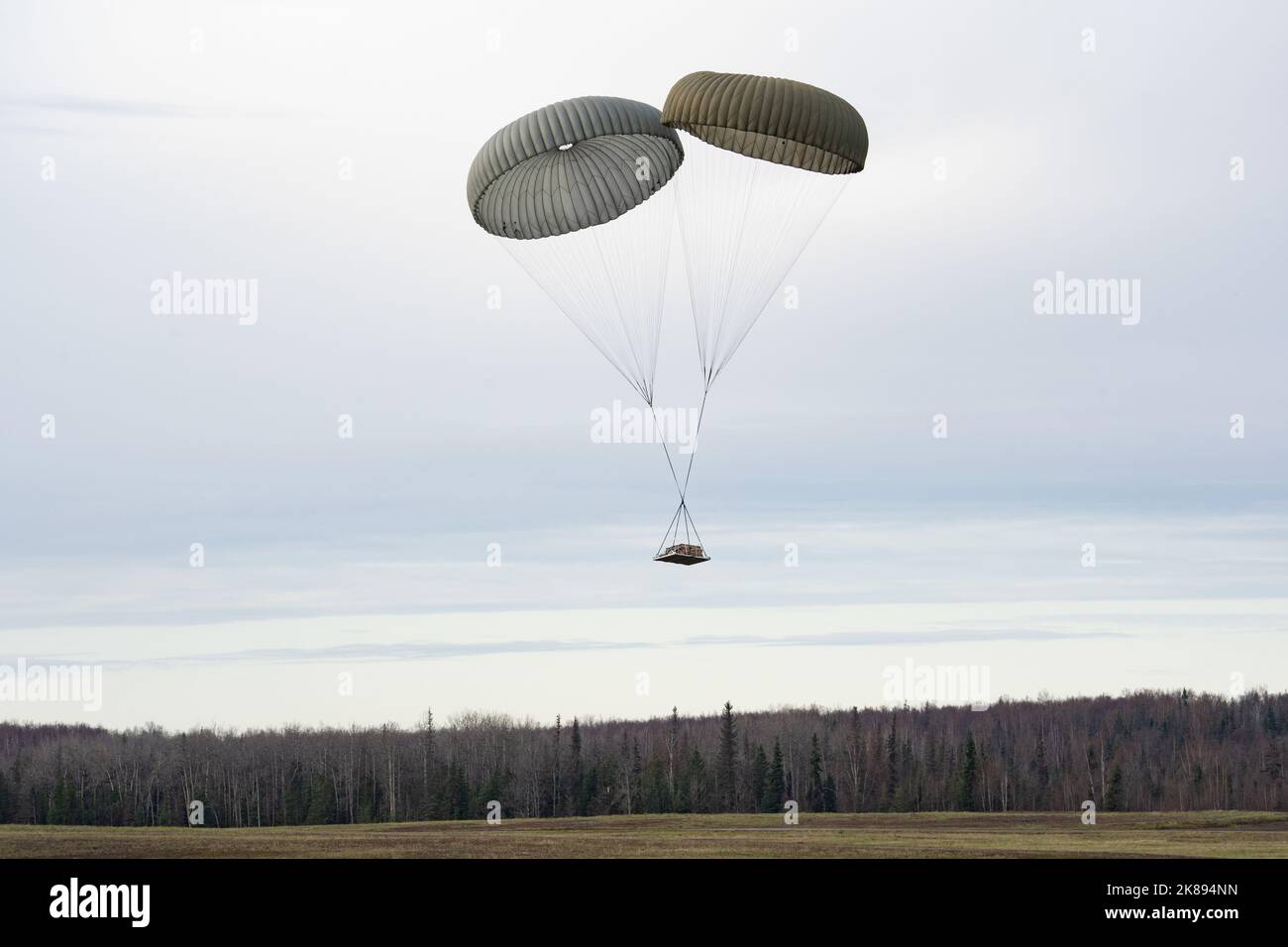 La cargaison tombe après qu'un Super Hercules C-130J de la Force aérienne des États-Unis affecté à l'aile de transport aérien de 317th, la base aérienne de Dyess, au Texas, a mené une formation de chute de cargaison pendant LE DRAPEAU ROUGE Alaska 23-1, à la zone de chute de Malemute sur la base conjointe Elmendorf-Richardson, en Alaska, le 19 octobre 2022. La RF-A 23-1 offre une opportunité d’engagement et de formation à l’échelle internationale dans un environnement différent de celui de la base d’origine de nombreuses unités. (É.-U. Photo de la Force aérienne par Airman 1st Class Julia Lebens) Banque D'Images