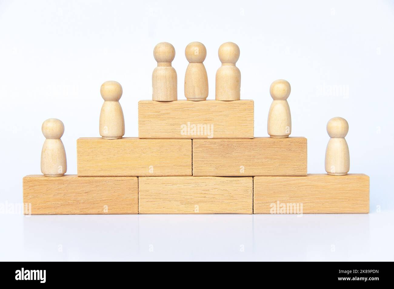Les personnes en bois se font une figure sur des blocs de bois. Réalisation des objectifs, croissance de l'entreprise et évolution de carrière. Banque D'Images