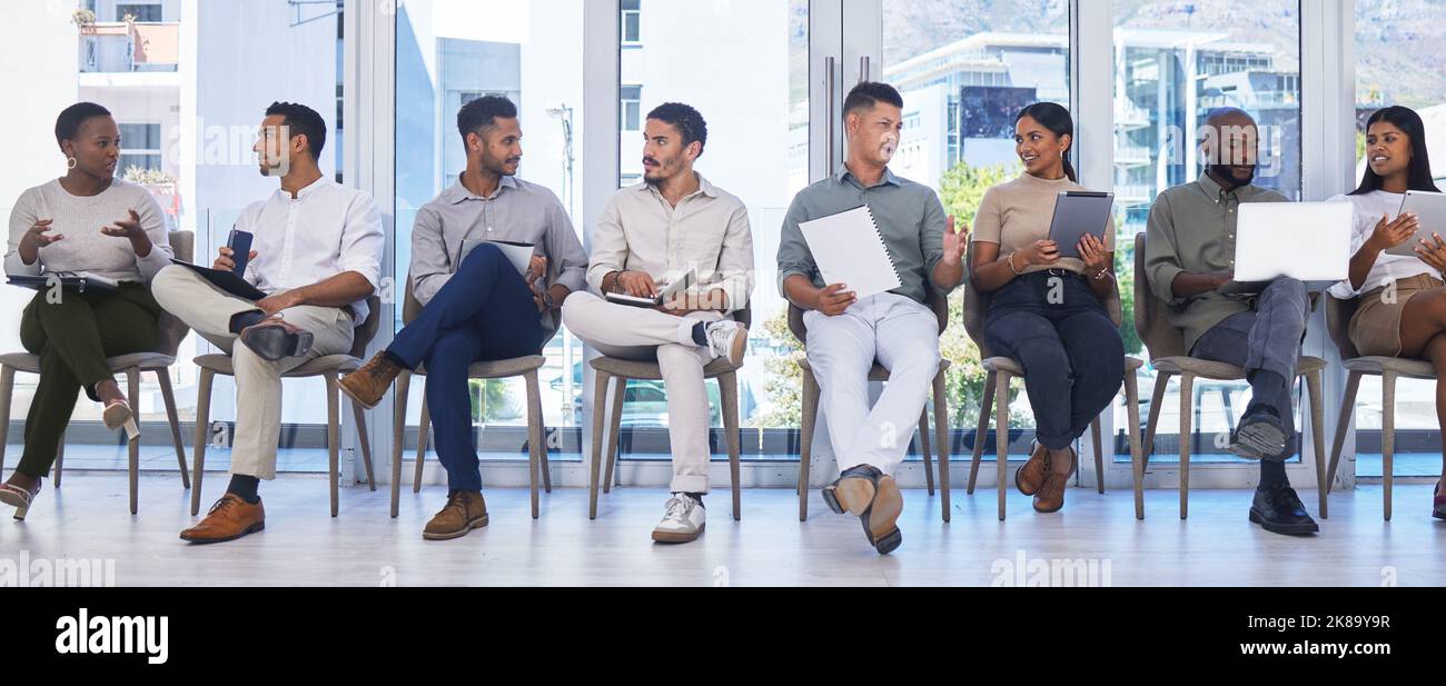 Un groupe de personnes attendant d'être interviewées pour un emploi dans un bureau moderne. Banque D'Images