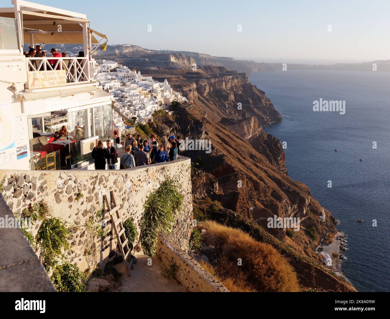 Restaurant avec vue sur la caldeira dans la ville de Fira au coucher du soleil. Île grecque des Cyclades de Santorin dans la mer Égée Banque D'Images