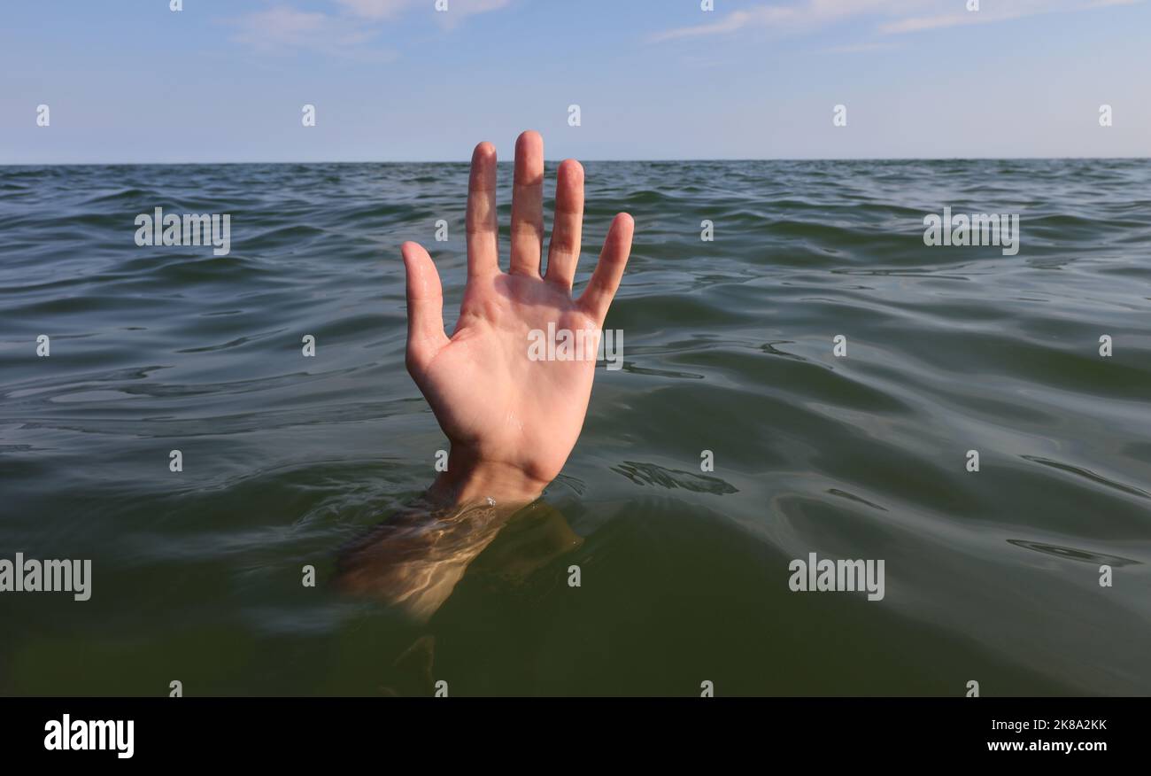 main de la personne avec cinq doigts au milieu de la mer sur le point de noyer Banque D'Images