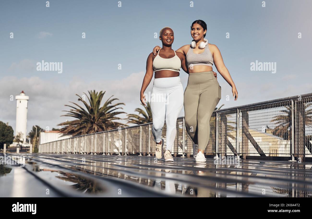 L'exercice est meilleur avec un ami. Deux jeunes femmes dehors pour une course ensemble. Banque D'Images