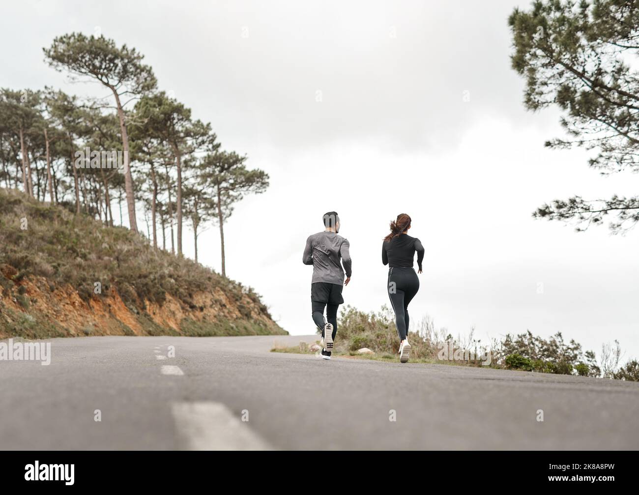 Nous courons pour nourrir nos âmes. Prise de vue en longueur de deux athlètes non reconnaissables se liant pendant une course en plein air. Banque D'Images