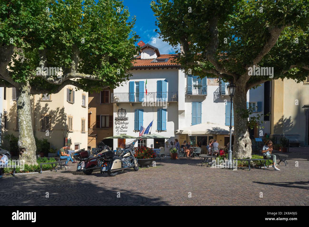 Cafe bar Italie, vue sur les personnes assis sur la terrasse à l'extérieur d'un bar populaire sur la Piazza San Giorgio dans la ville pittoresque de Varenna, lac de Côme, Lombardie Banque D'Images