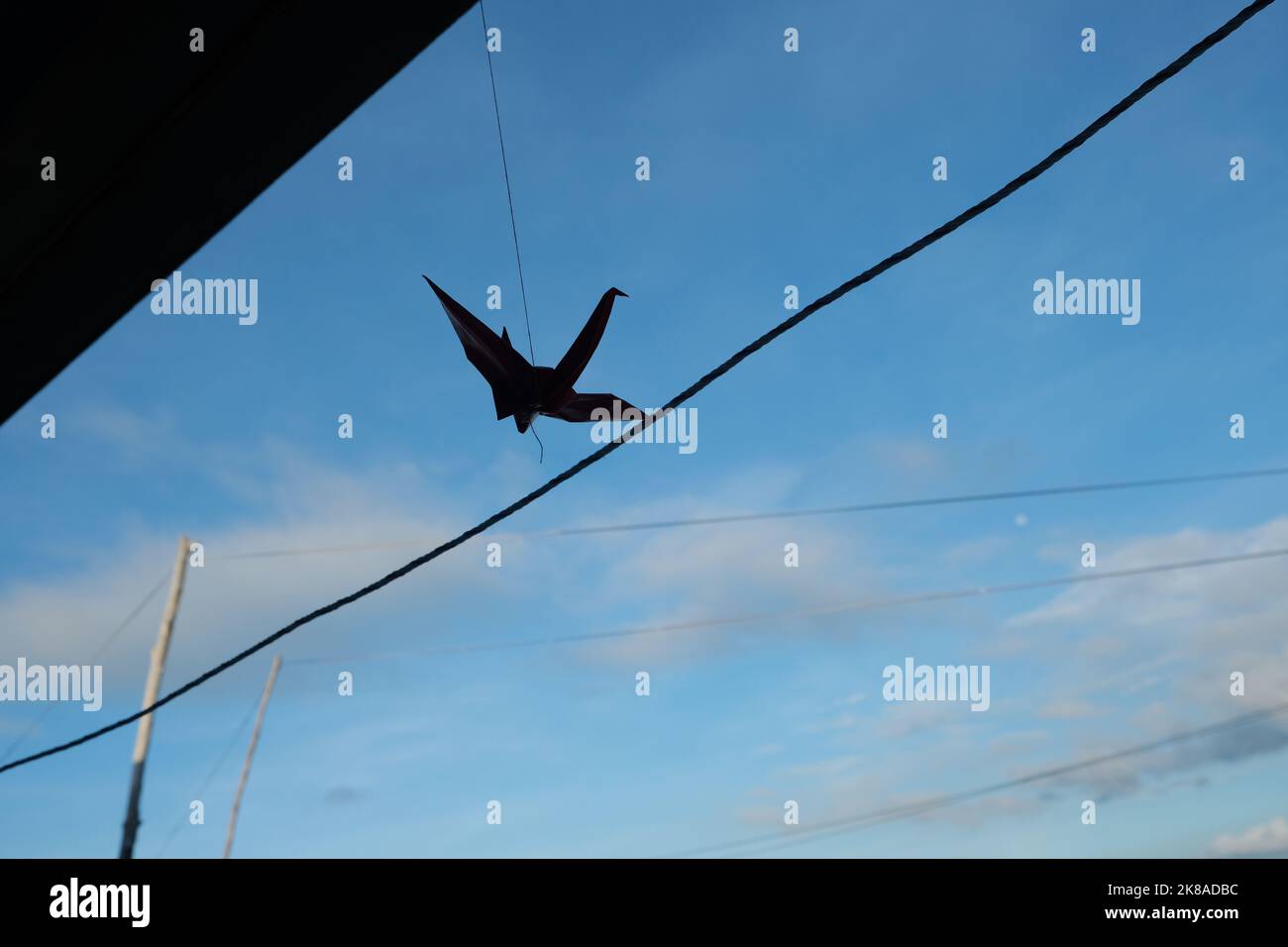 La silhouette d'une grue en papier accrochée à l'extérieur d'une école de village de bajau. Banque D'Images