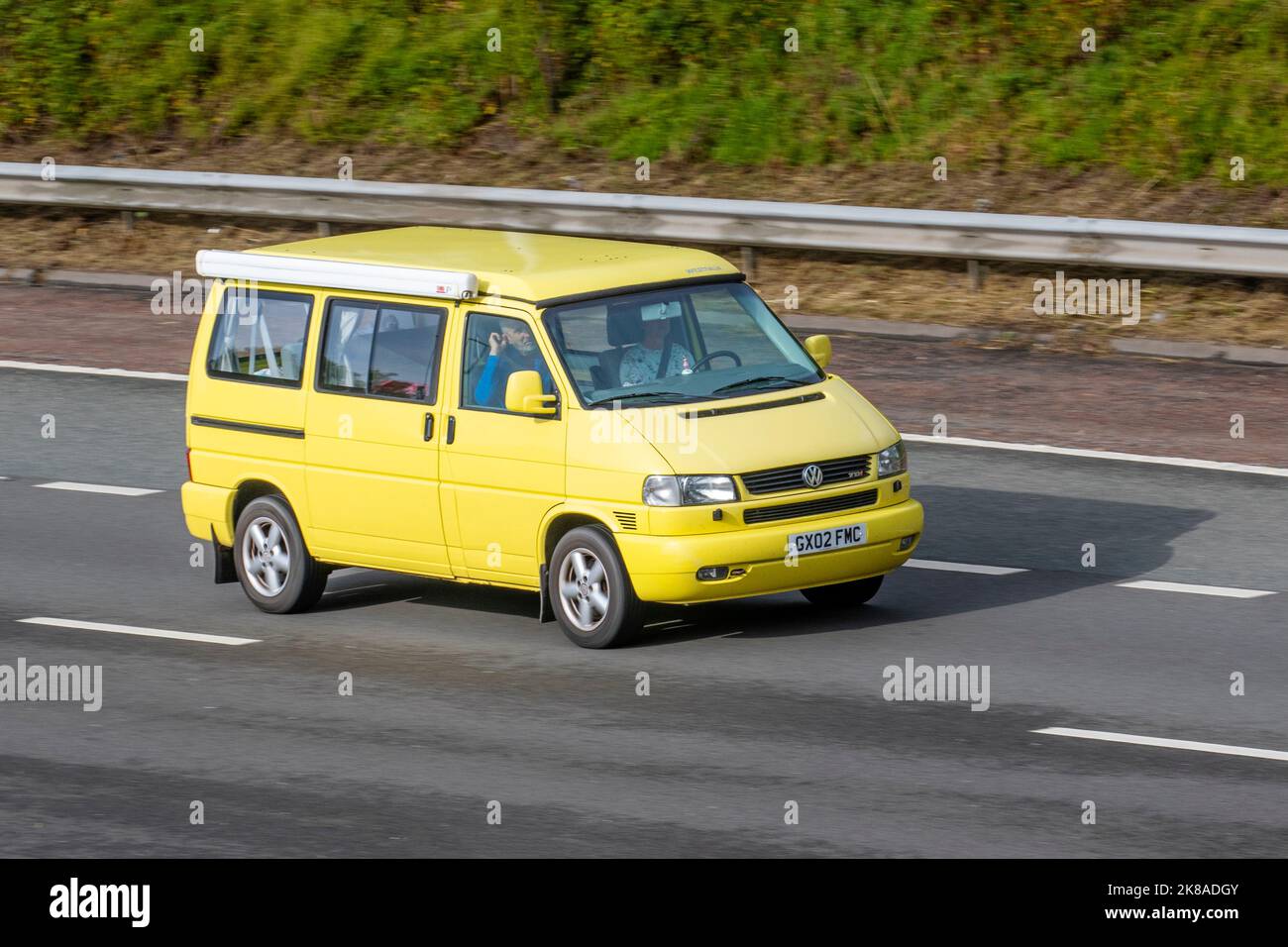 2002 jaune VW VOLKSWAGEN Multivan Umwelt 2496cc Diesel manuel ; déplacement sur l'autoroute M6, Royaume-Uni Banque D'Images