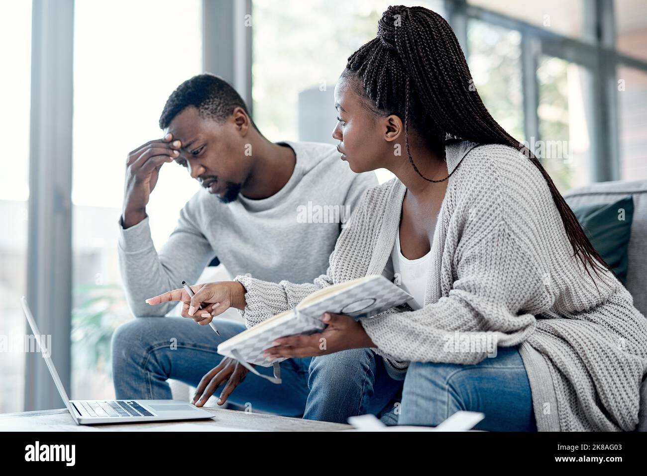 Plus de dépenses, plus de tension. Un jeune couple ayant un argument tout en travaillant sur leurs finances à la maison. Banque D'Images