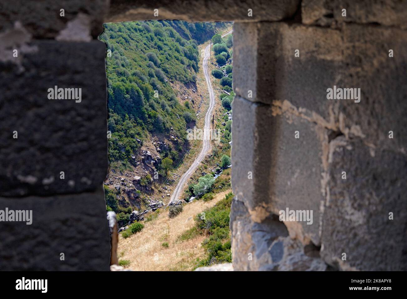 Vue sur la route de la forêt depuis le haut, par la fenêtre de la forteresse d'Amberd, en été Banque D'Images