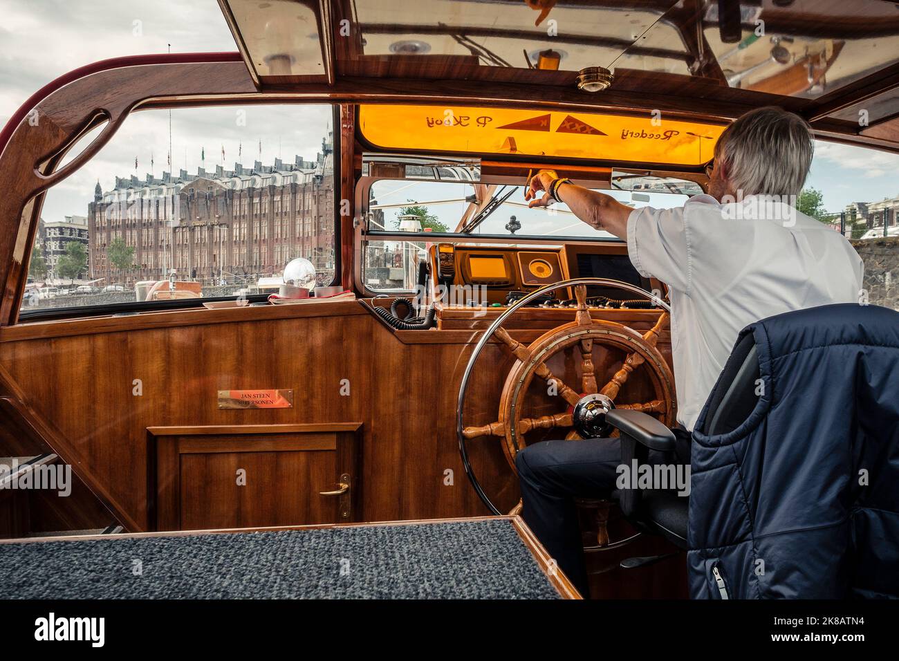 Pilote de voyage en bateau sur le canal d'Amserdam montrant la gare centrale d'amsterdam, amsterdam, pays-bas Banque D'Images