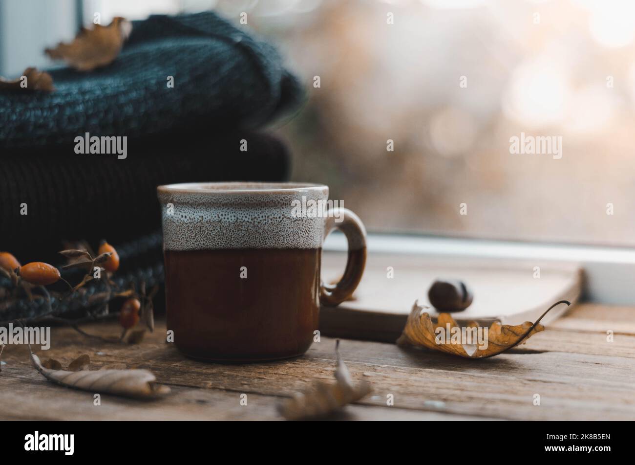 Grande tasse de cappuccino sur fond brun vintage. Automne, feuilles d'automne, tasse de café chaud et une écharpe chaude sur fond de table en bois. Mers Banque D'Images