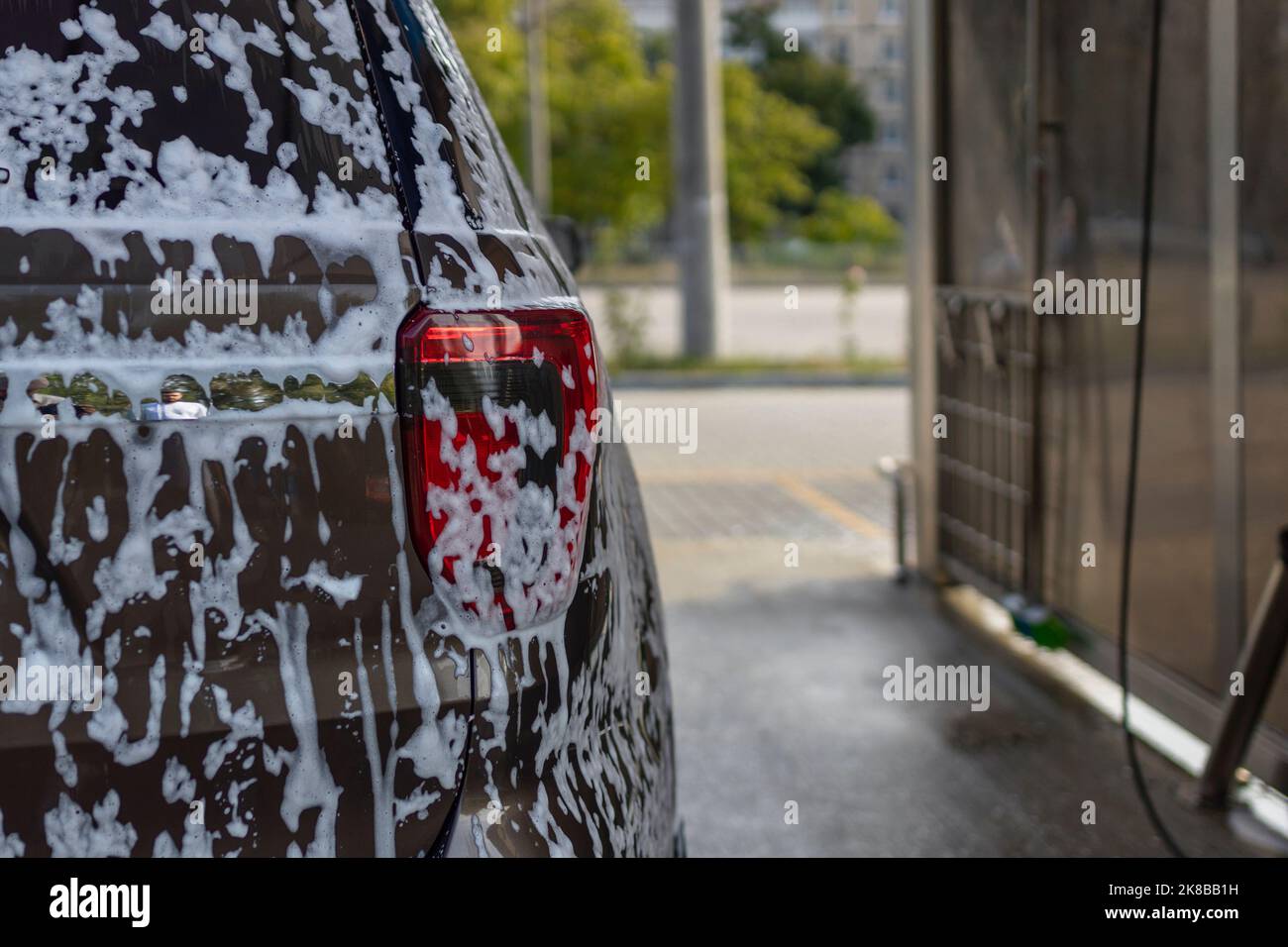 la butée arrière de la voiture est recouverte de mousse de savon . lavage de voiture en libre-service Banque D'Images