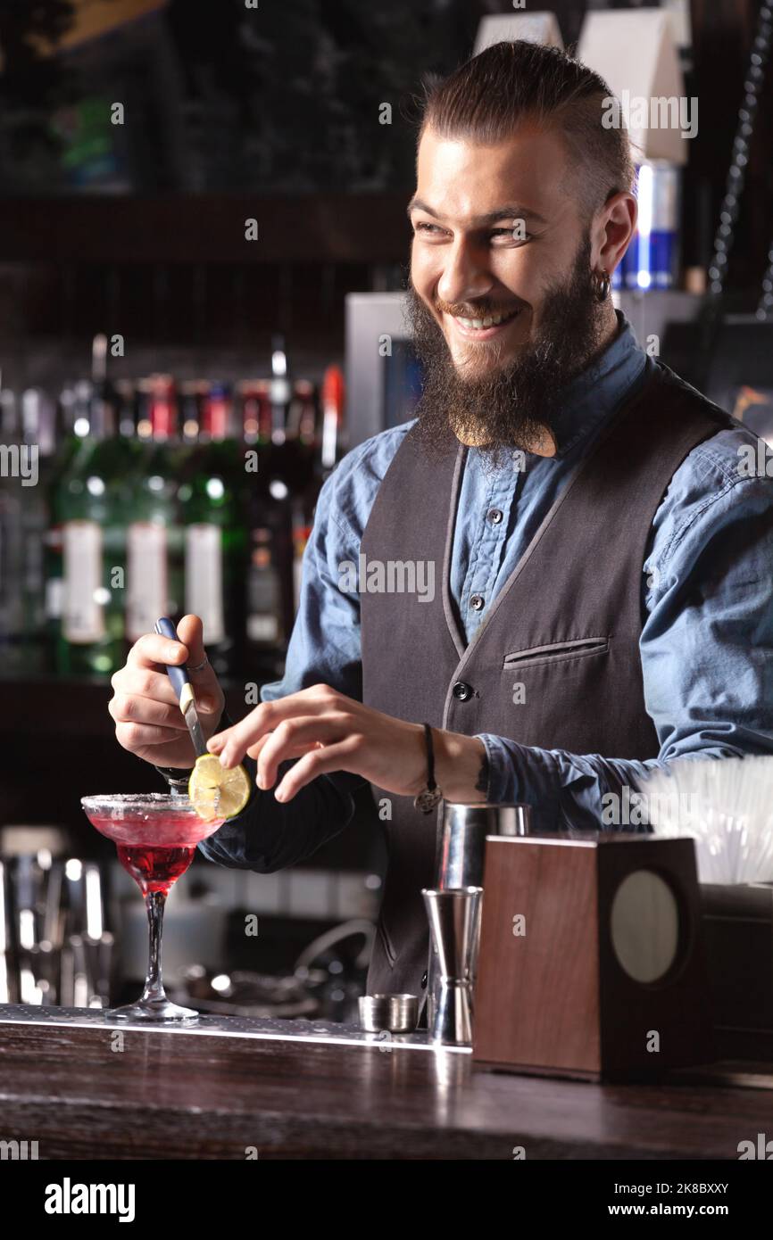Portrait d'un barman heureux qui fait un cocktail. Banque D'Images