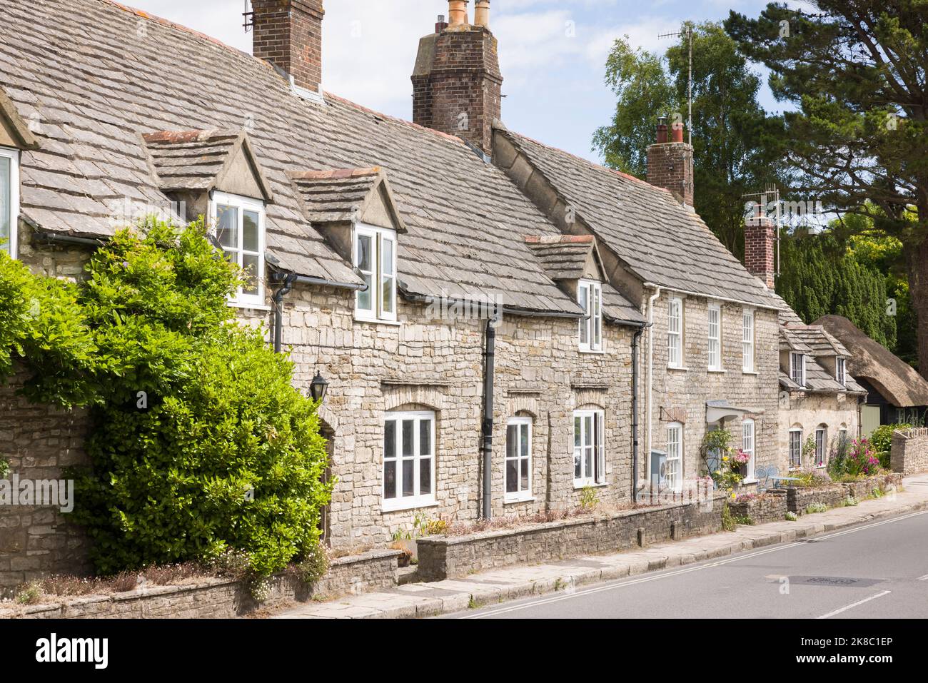 Rangée de vieilles maisons en pierre, maisons mitoyennes dans le village du château de Corfe, Dorset Banque D'Images