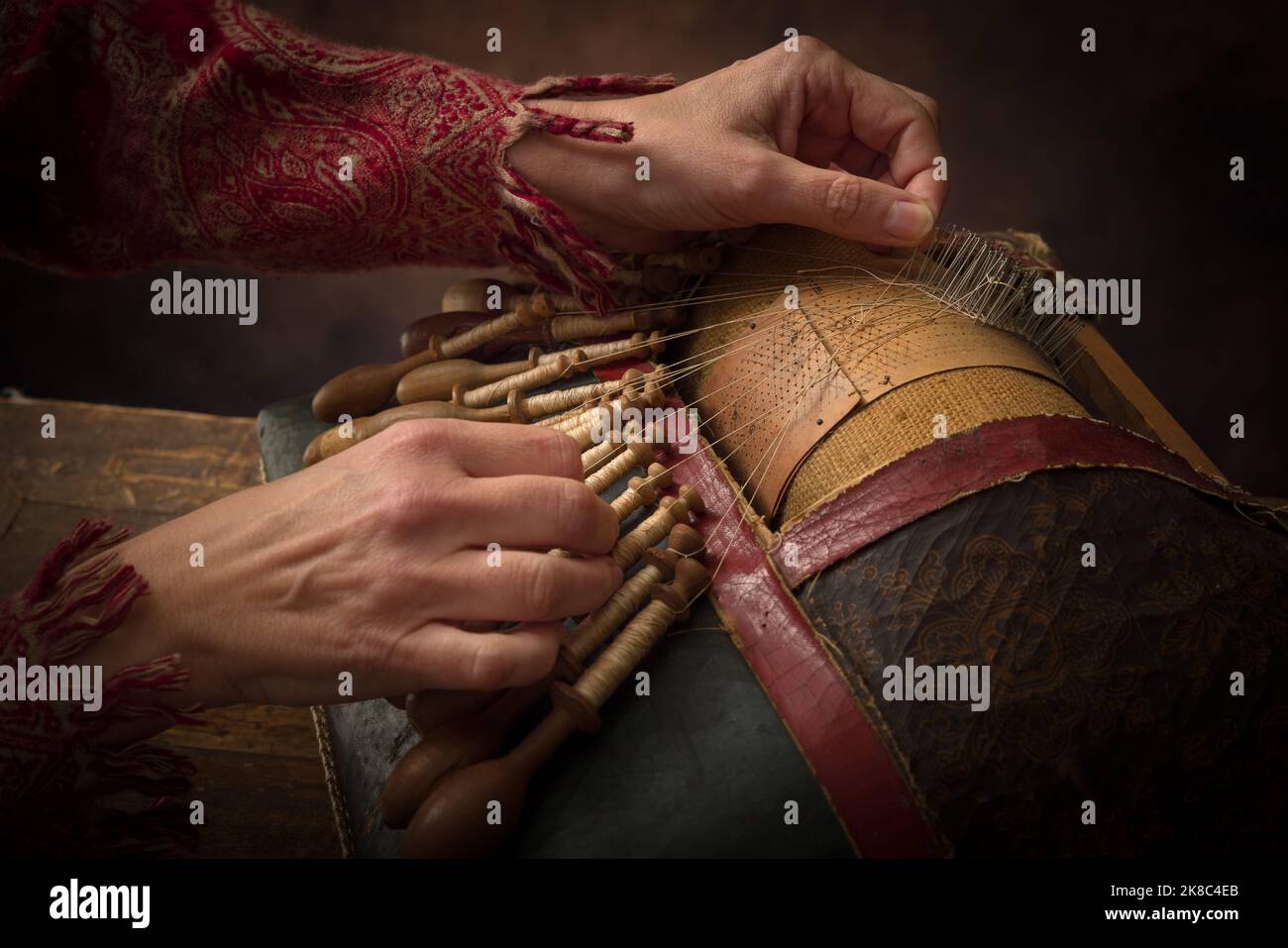 Mains d'une femme travaillant sur un ancien oreiller de fabrication de dentelle flamande Banque D'Images