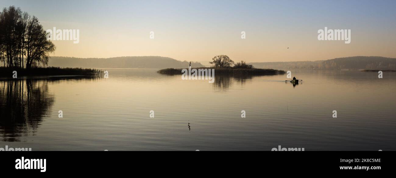 île sur le lac le matin avec brouillard et pêcheur Banque D'Images