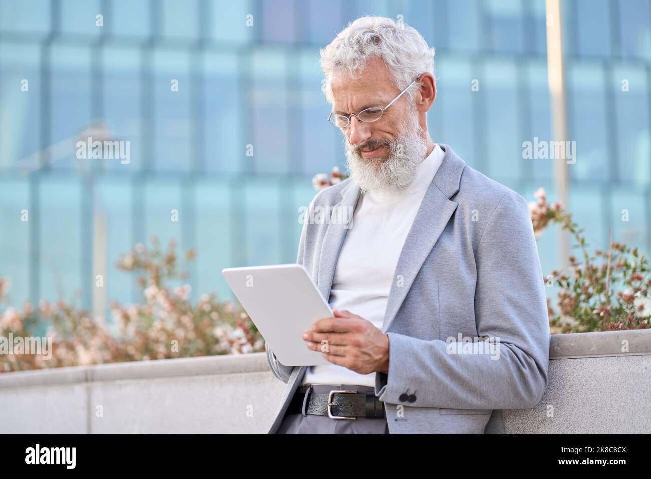 Ancien homme d'affaires professionnel adulte utilisant une tablette numérique à l'extérieur. Banque D'Images