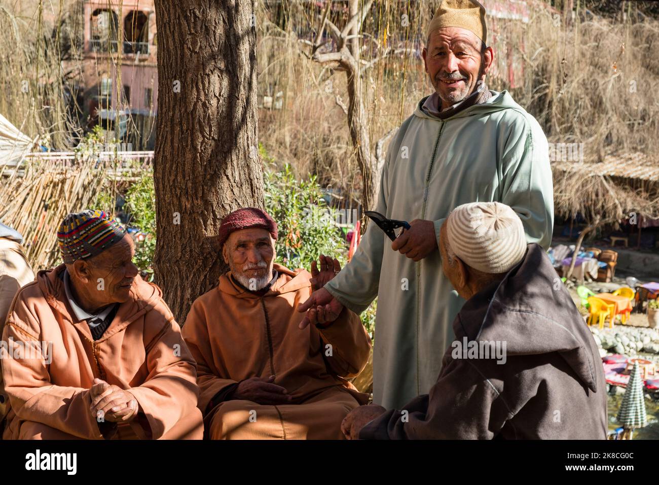 Quatre hommes marocains en vêtements traditionnels se rassemblent dans la rue de Setti Fatma, une petite ville de la vallée de l'Ourika, en Afrique du Nord Banque D'Images