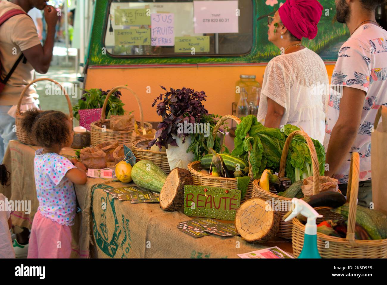 Petite fille devant un stand de produits locaux et de jus de fruits frais, Genève Banque D'Images