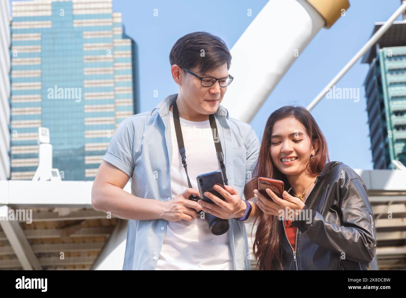 voyage en asie. jeune couple asiatique souriant et heureux regardant un smartphone pour rechercher des informations de voyage et une carte de localisation à partir de l'application de voyage. Banque D'Images
