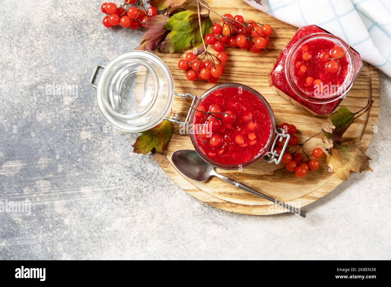 Viburnum mûr frais avec sucre pour la préparation de la vitamine et thé antioxydant sur une table en pierre. Source de vitamines naturelles. Utilisé en médecine populaire. Banque D'Images