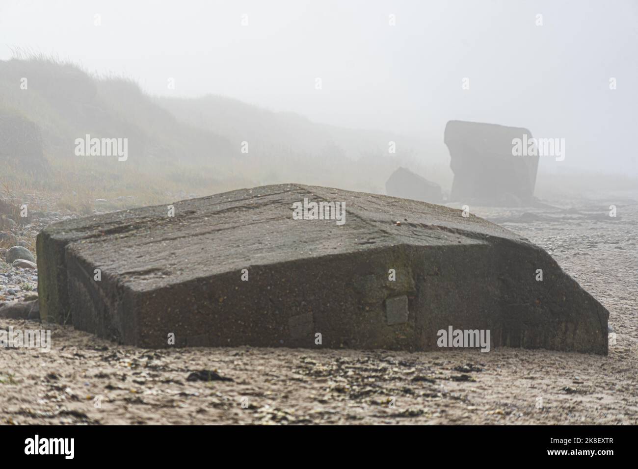 Anciennes fortifications côtières allemandes pourriture sur une plage dans la brume matinale Banque D'Images