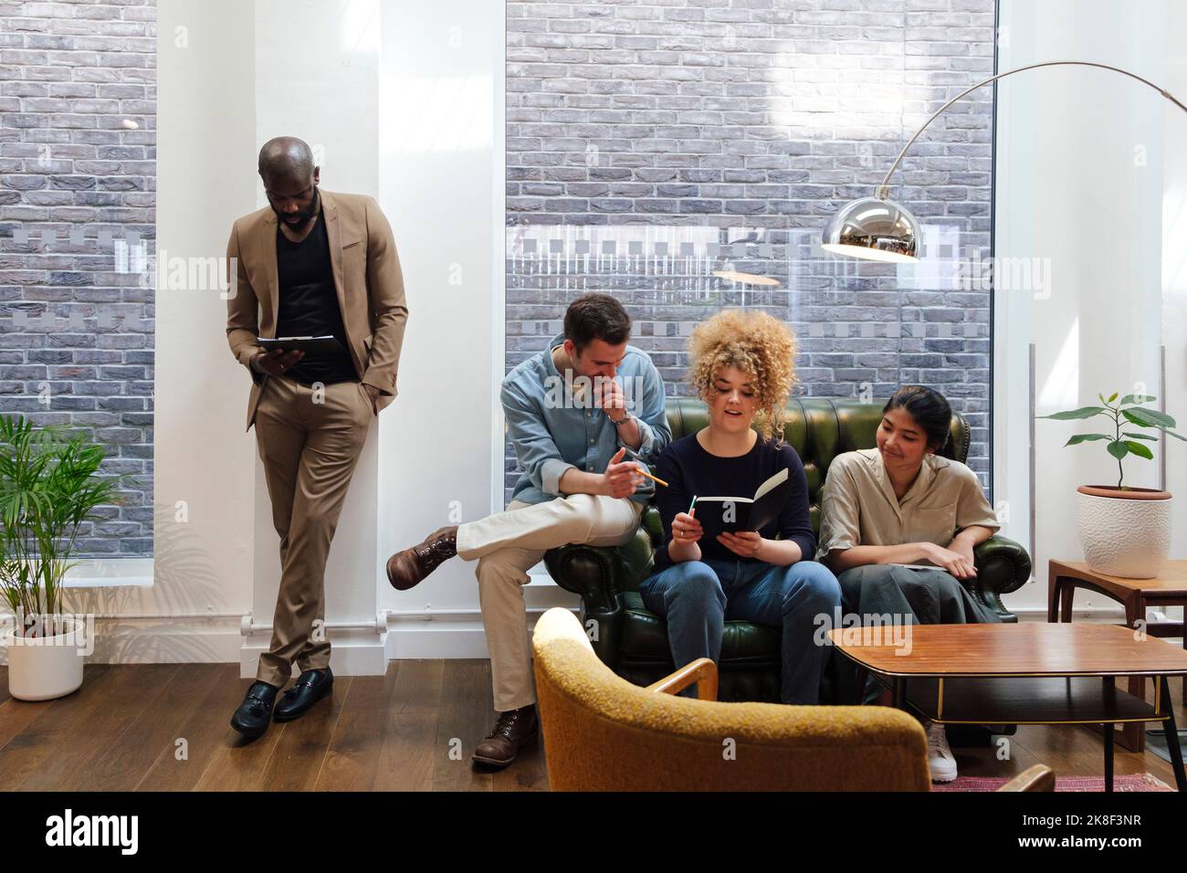 Les gens d'affaires assis dans un espace de travail de collègue moderne remue-méninges ensemble Banque D'Images