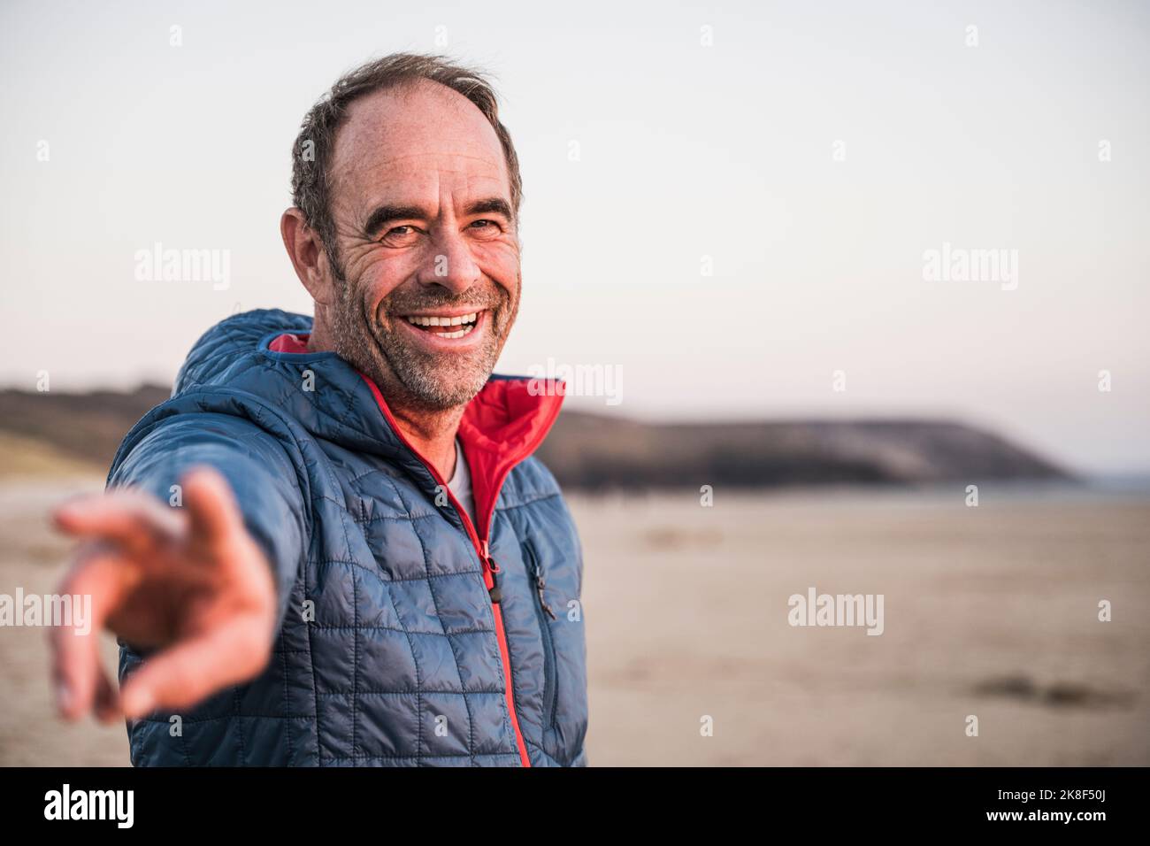 Heureux homme mature gesturant signe de paix à la plage Banque D'Images