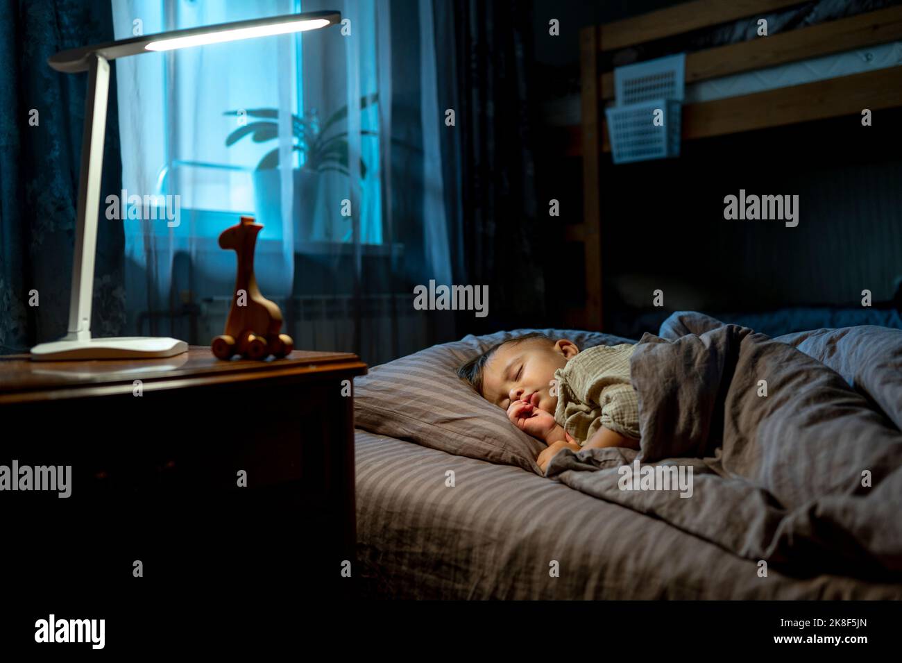 Bébé garçon mignon dormant sur le lit Banque D'Images