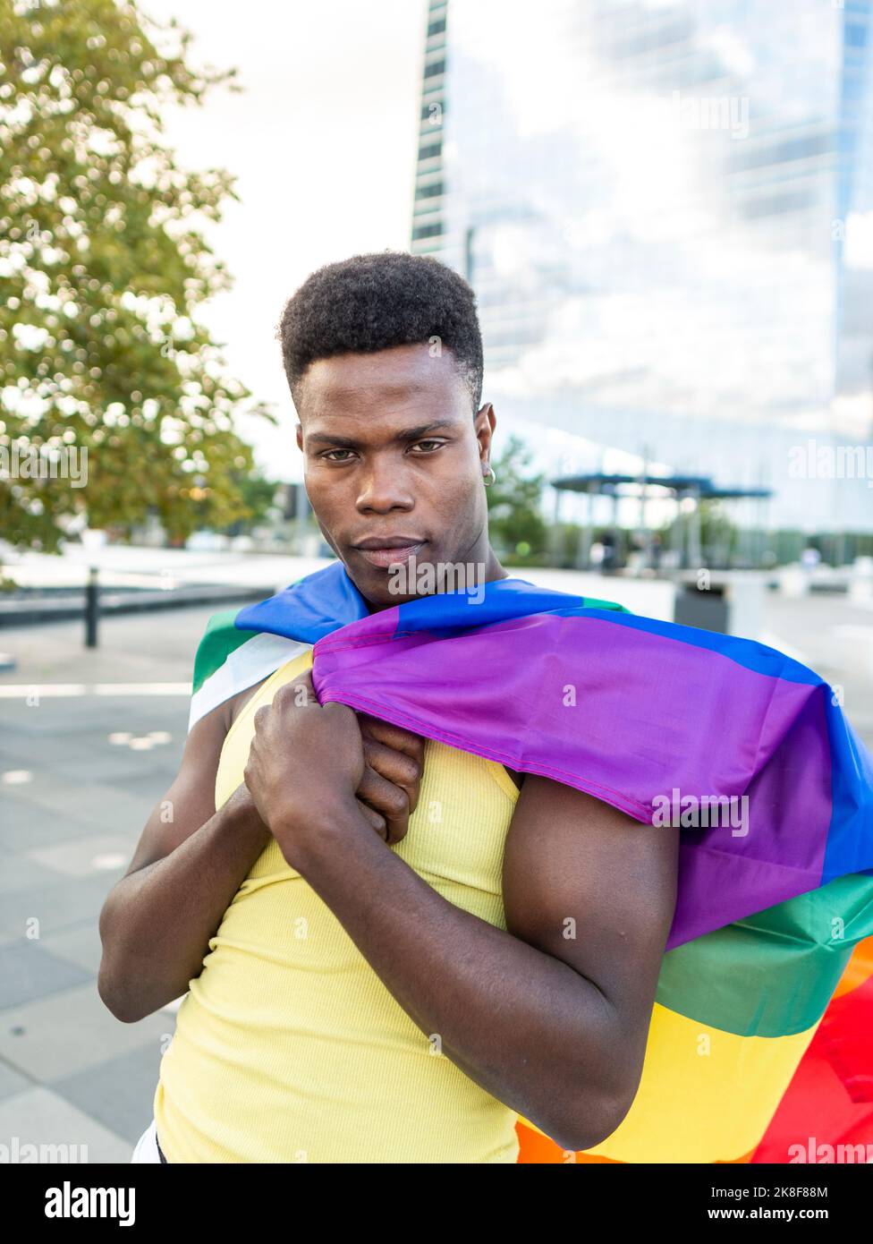 Jeune homme confiant, drapeau arc-en-ciel sur la piste Banque D'Images