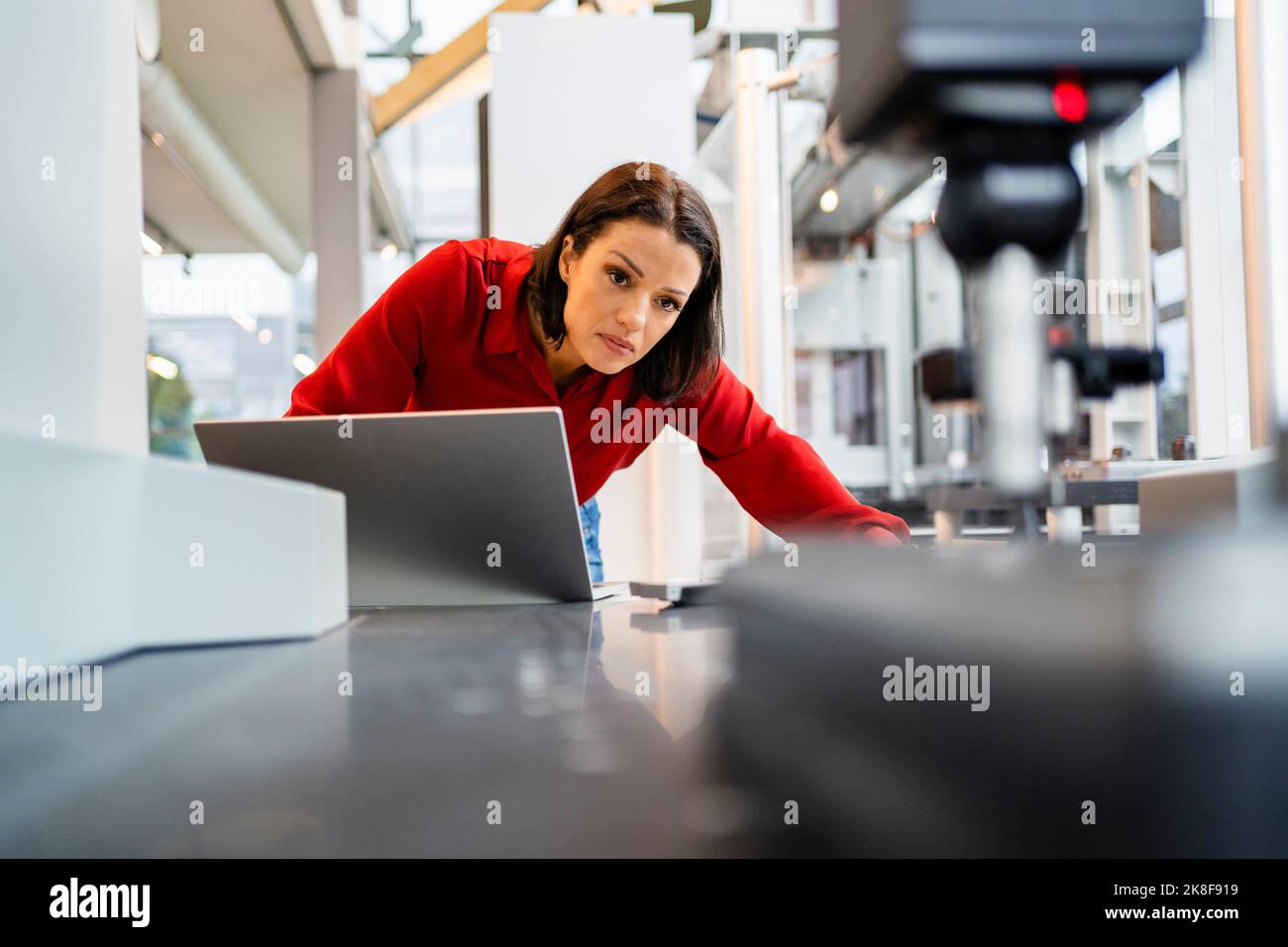Ingénieur concentré avec machine d'examen portable en usine Banque D'Images