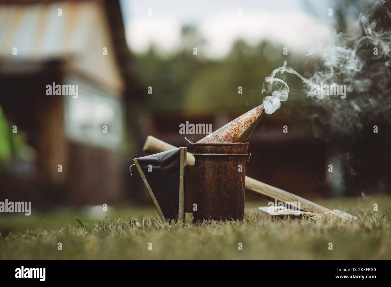 Fumeur d'abeille gardé sur l'herbe à l'apiaire Banque D'Images