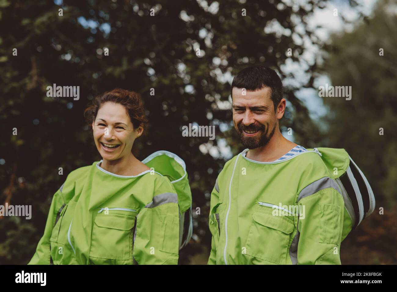 Un gardien de chambre joyeux avec un collègue portant des tenues de protection vertes Banque D'Images