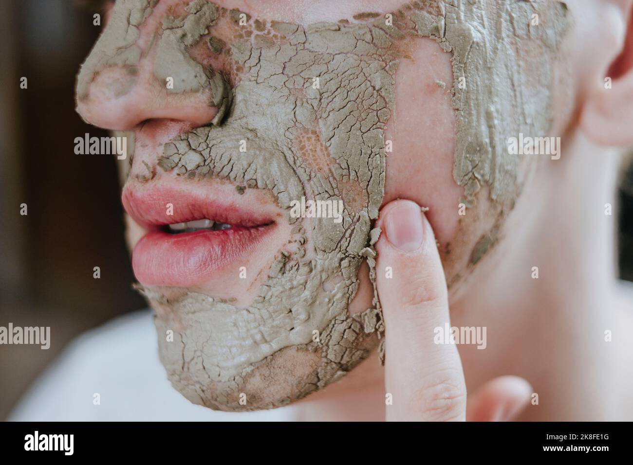 Maquilleur supprimant le masque facial avec le doigt Banque D'Images