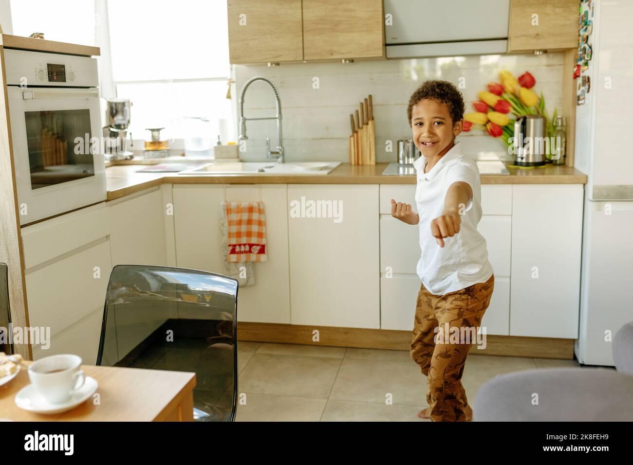 Joyeux garçon en faisant des gestes dans la cuisine Banque D'Images Joyeux garçon en faisant des gestes dans la cuisine Banque D'Images