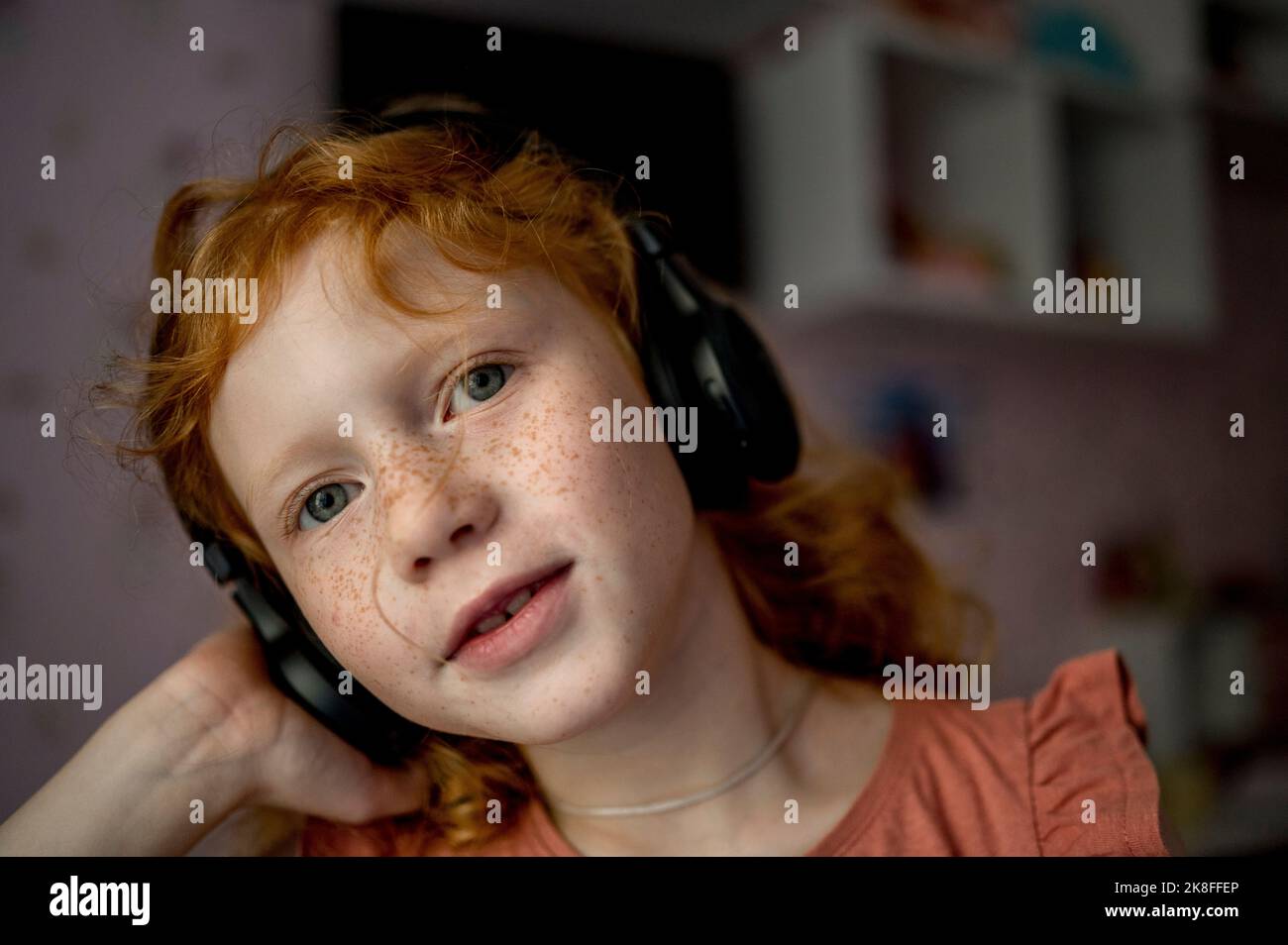 Fille avec un casque sans fil qui écoute de la musique à la maison Banque D'Images