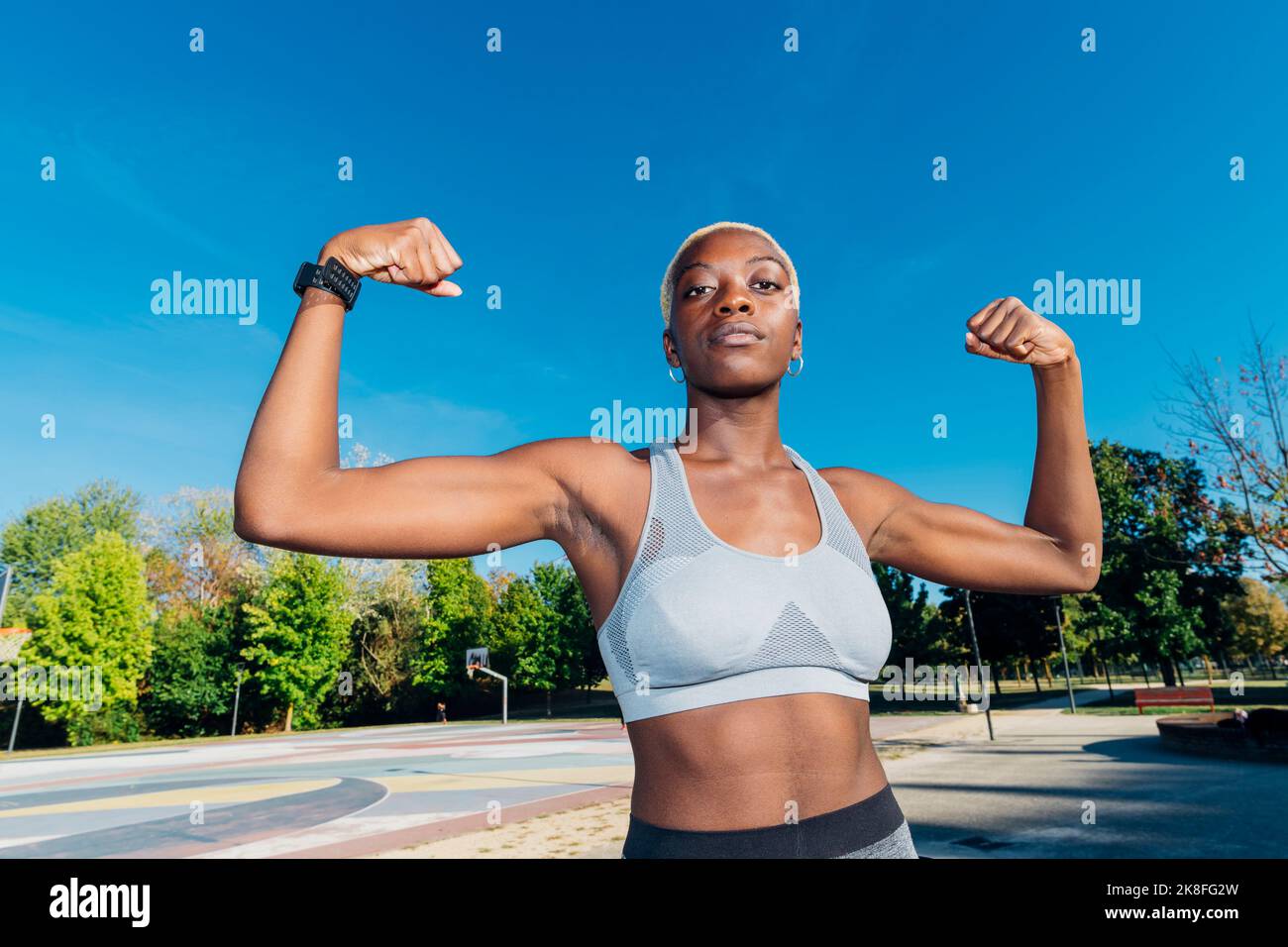 Jeune athlète montrant des biceps sur un terrain de sport Banque D'Images