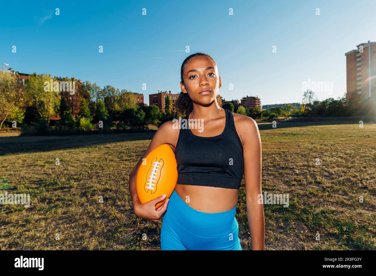 Joueur de football américain confiant avec ballon de sport sur le terrain Banque D'Images