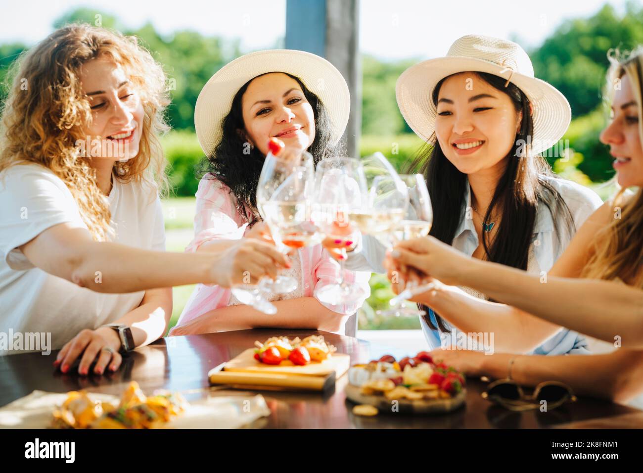 Des amis qui toaster des verres de vin assis à table Banque D'Images