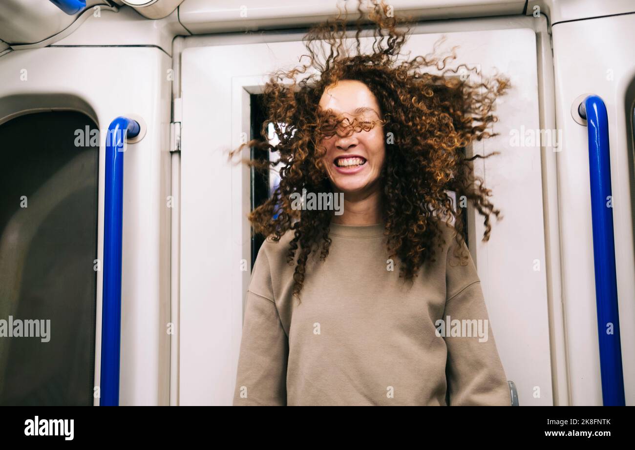 Femme aux cheveux balayés par le vent voyageant dans le métro Banque D'Images