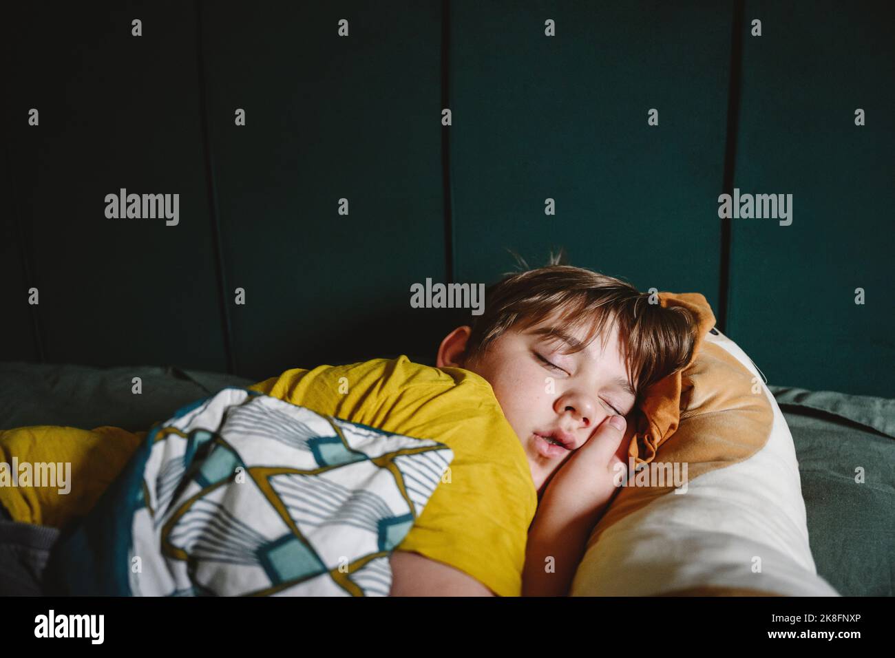 Garçon dormant au lit à la maison Banque D'Images
