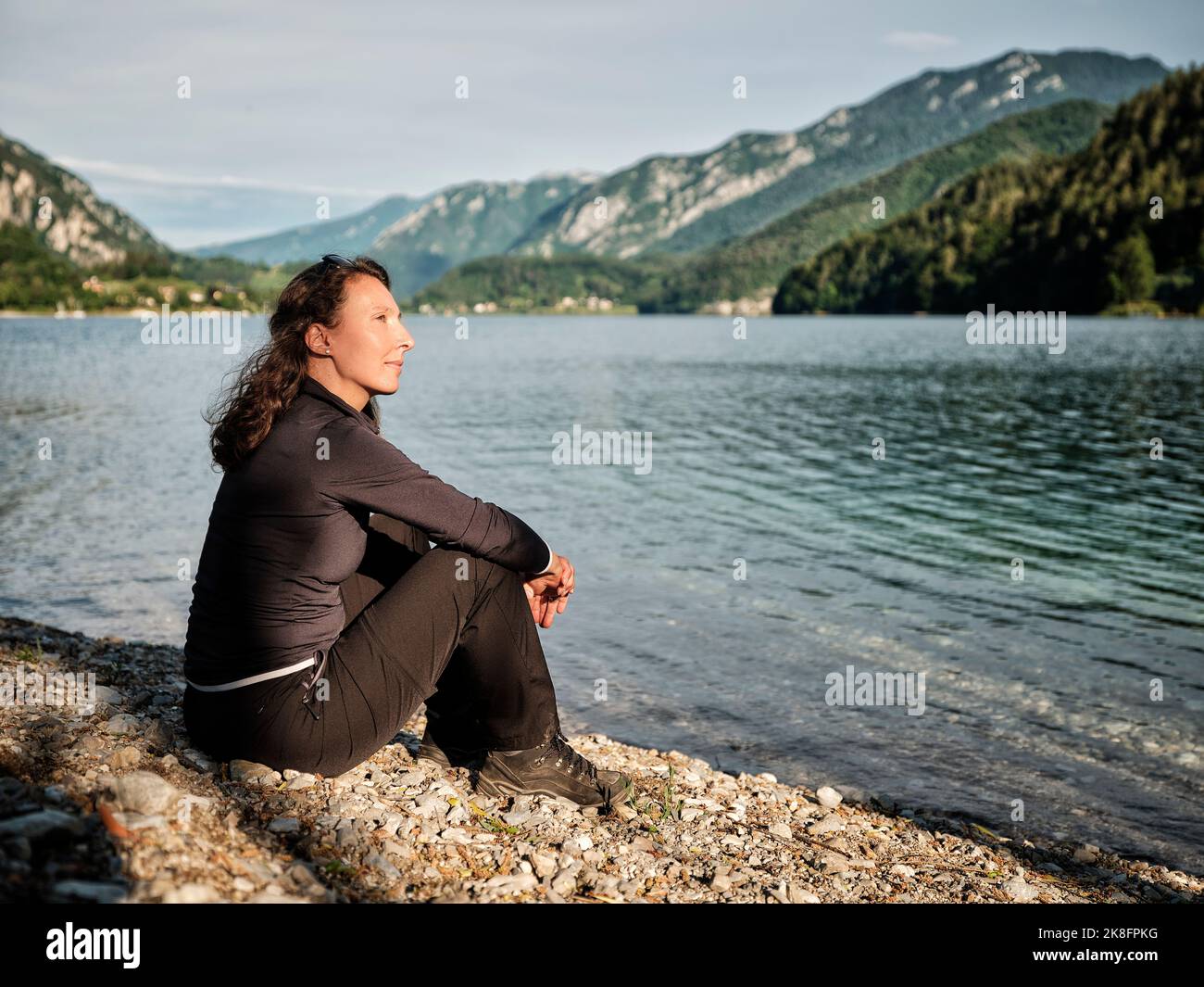 Femme attentionnés se relaxant au bord du lac Banque D'Images