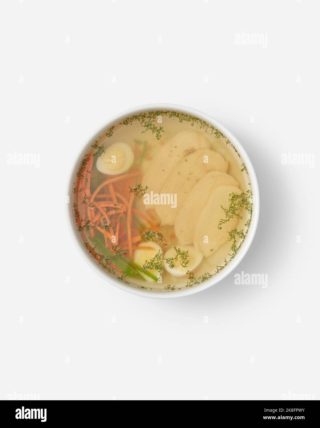 Soupe de poulet avec œuf et légumes dans un bol sur fond blanc Banque D'Images